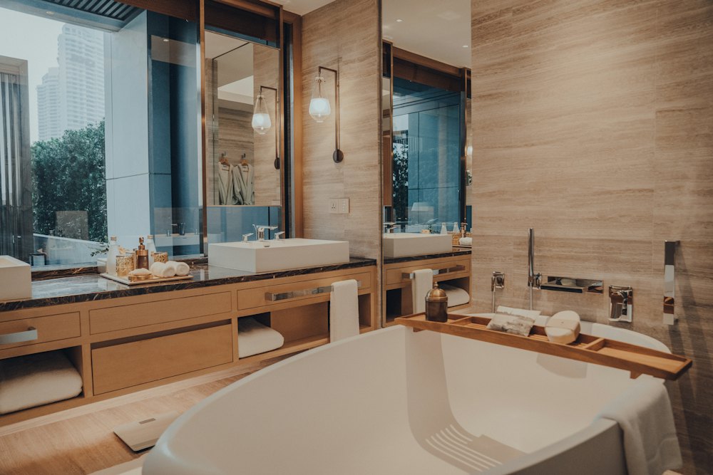 A freestanding bath beside a window