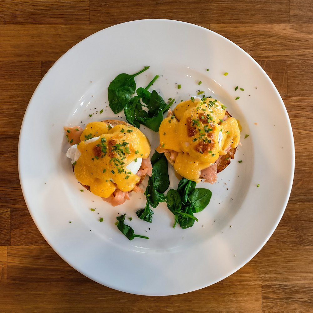 Eggs Benedict with spinach on a white plate