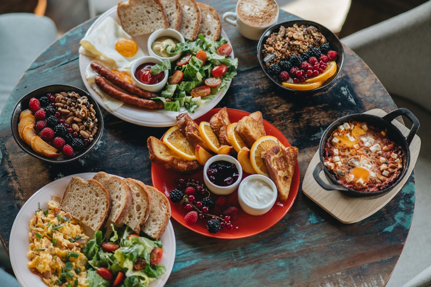 A brunch table laid with eggs, toast, fruit and coffee