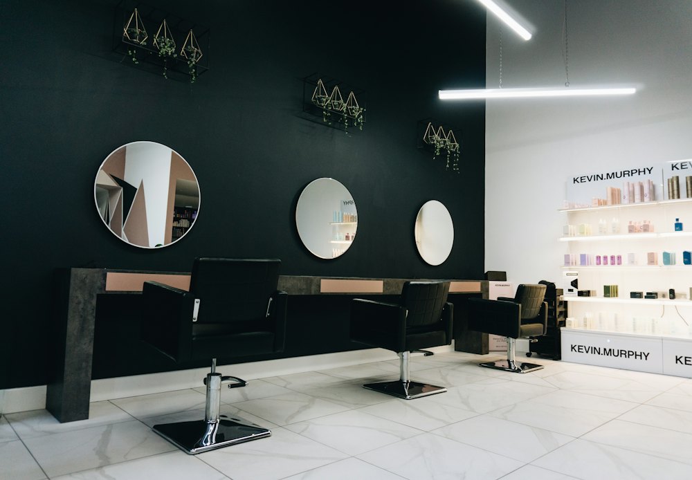 The salon floor with three chairs and round mirrors